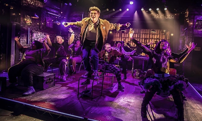 Blake Patrick Anderson (Mark) and the Company of RENT at Hope Mill Theatre.